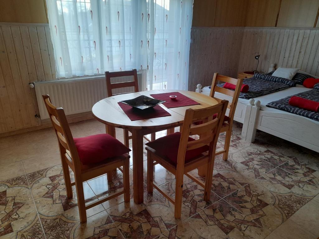 a room with a table and chairs and a bed at Anatan Apartmanok Harkány in Harkány