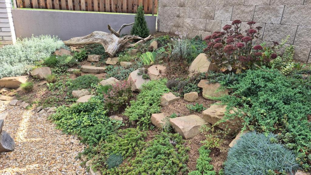 a garden with rocks and plants in a yard at Orlická přehrada Chata Malá in Kožlí u Orlíka
