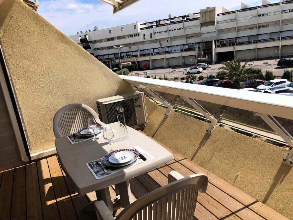 d'une table et de chaises sur un balcon avec vue sur le parking. dans l'établissement Résidence Héliopolis Bâtiment E - Studio 2 pers. HELIOPOLIS E MAE-4594, au Cap d'Agde