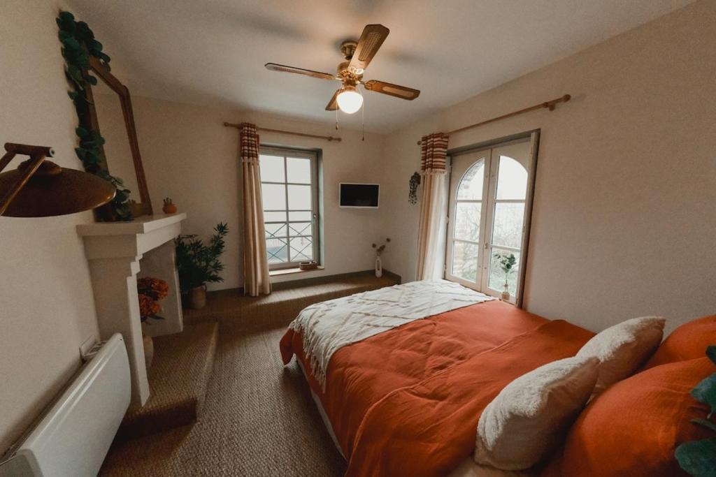 a bedroom with a bed and a ceiling fan at Le Charme - Petite Maison in La Ferté-Bernard