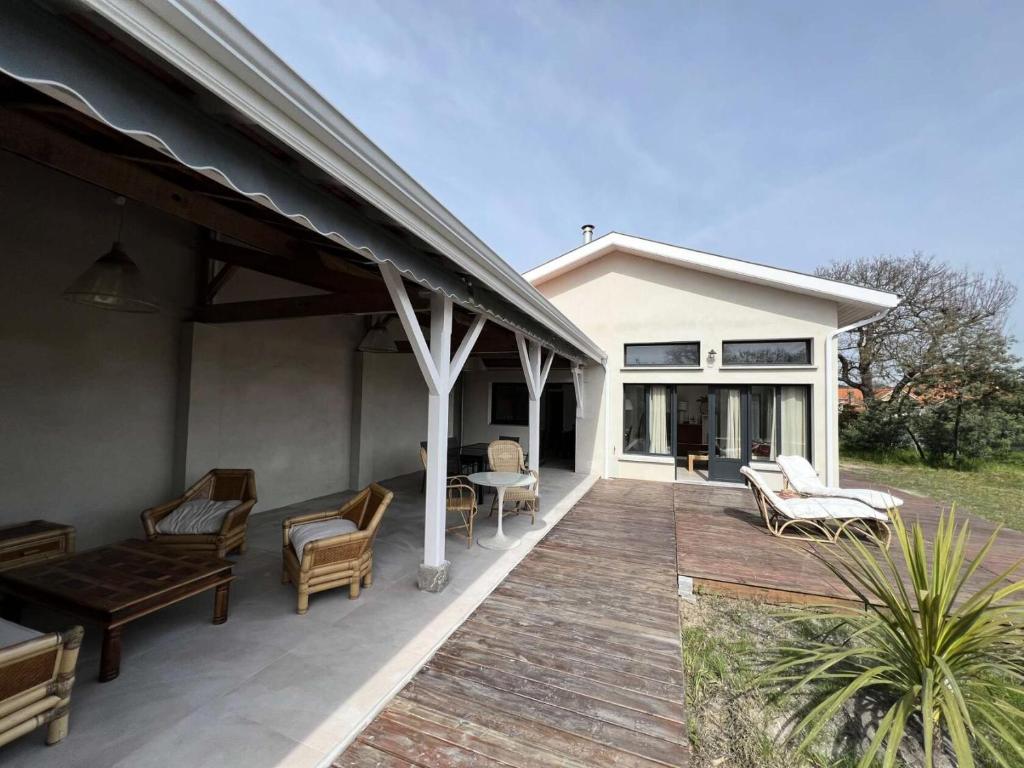 a patio with chairs and tables on a house at Résidence 096-soulac Sur Mer - 096 - Séjournez dans le charme de Soulac/mer : maison cosy avec jardin MAE-4441 in Soulac-sur-Mer