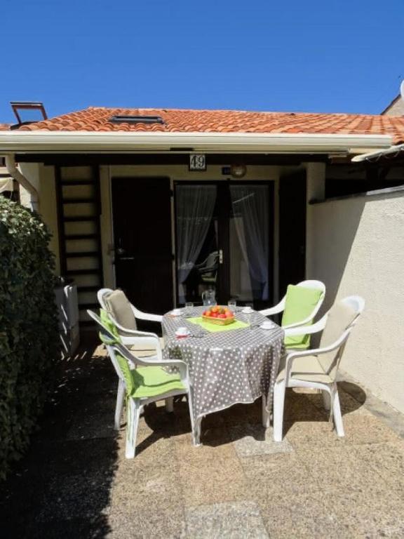 une table et des chaises assises sur une terrasse dans l'établissement Résidence Hameau De L'amélie - 053 - Jolie maisonnette classée 3 au Hameau de l'Amélie MAE-6091, à Soulac-sur-Mer