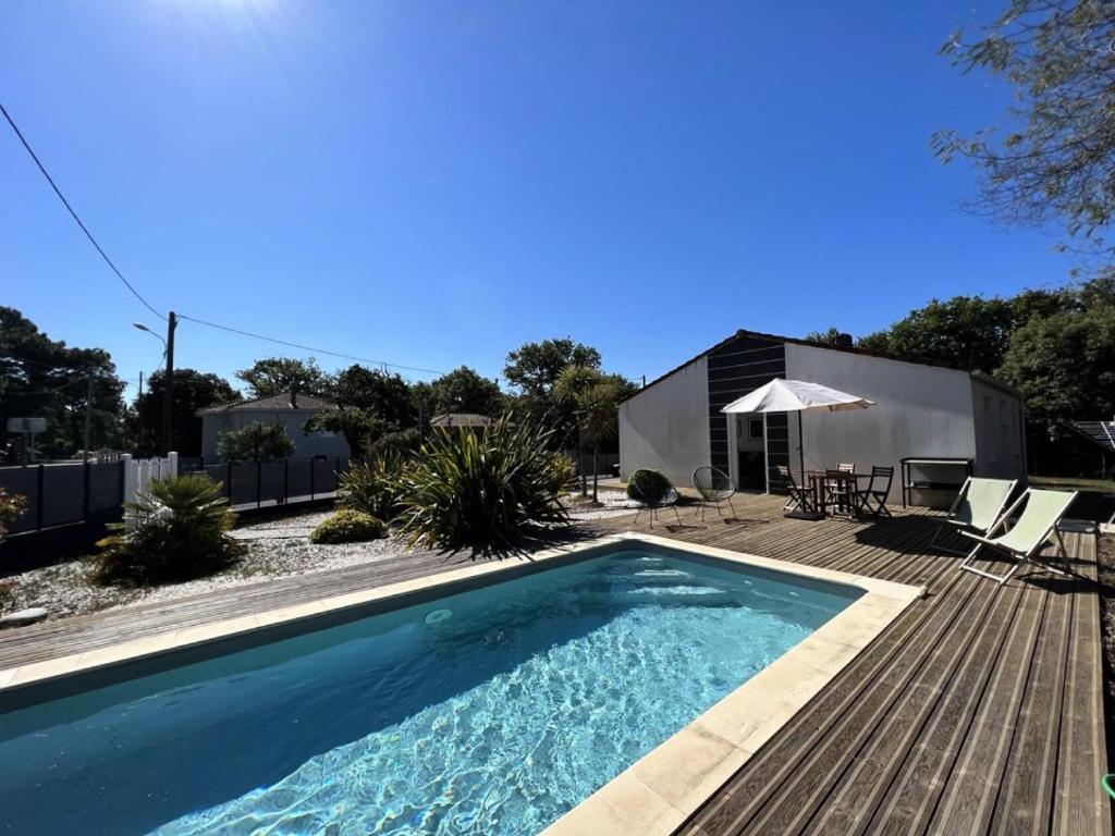 une piscine avec une terrasse et une maison dans l'établissement Résidence 008-soulac Sur Mer - 008 - Jolie villa contemporaine avec piscine MAE-6151, à Soulac-sur-Mer