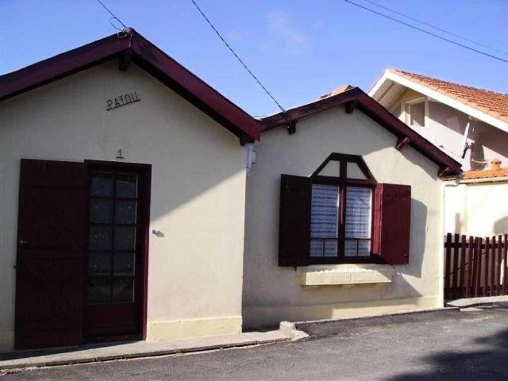 une maison blanche avec une porte et une fenêtre noires dans l'établissement Résidence 048-soulac Sur Mer - 048 - Maison au calme proche du centre-ville MAE-2341, à Soulac-sur-Mer