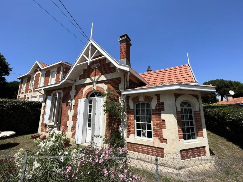 une petite maison en briques avec un toit dans l'établissement Résidence 082-soulac Sur Mer - 082 - Jolie Soulacaise à 5 mns du centre ville MAE-2381, à Soulac-sur-Mer