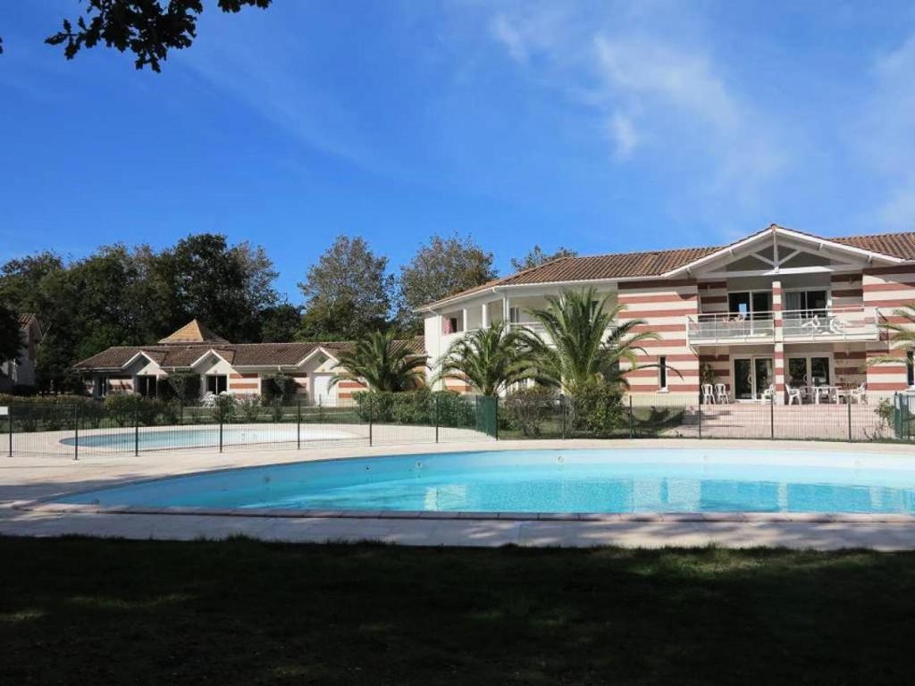 une grande piscine devant une maison dans l'établissement Résidence Domaine Des Sables - 073 - Domaine des Sables classé 3 étoiles maison en duplex MAE-3651, à Soulac-sur-Mer