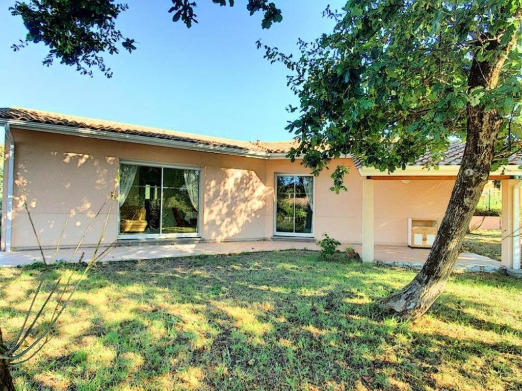 une maison blanche avec un arbre dans la cour dans l'établissement Résidence 060-soulac Sur Mer - 060 - Agréable maison avec jardin à Soulac/mer MAE-3641, à Soulac-sur-Mer