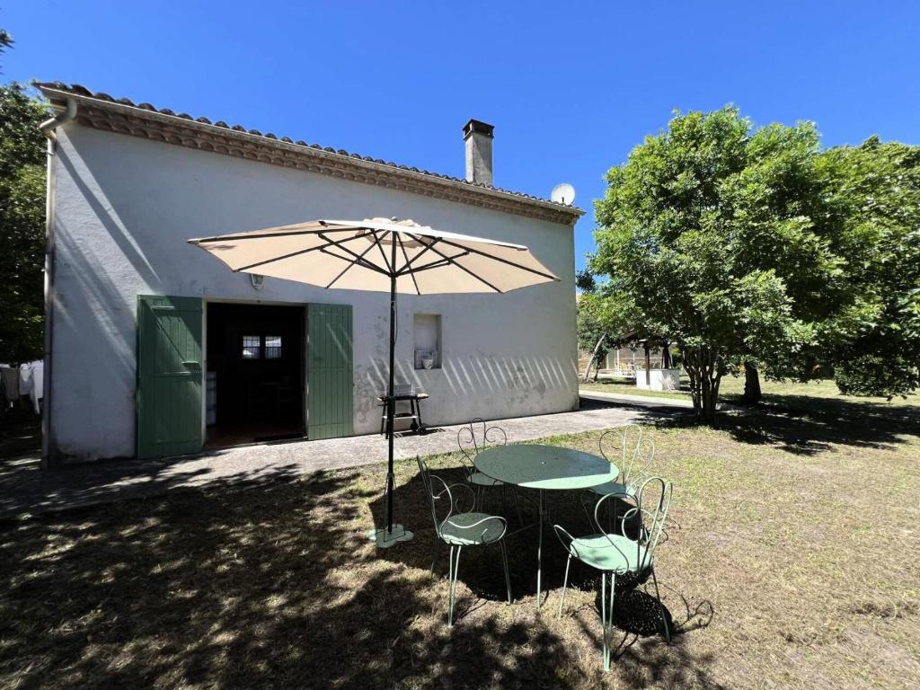 une table et des chaises avec un parasol en face d'un bâtiment dans l'établissement Résidence 106-st Vivien De Medoc - 106 - Agréable maison avec son grand parc MAE-3681, à Saint-Vivien-de-Médoc