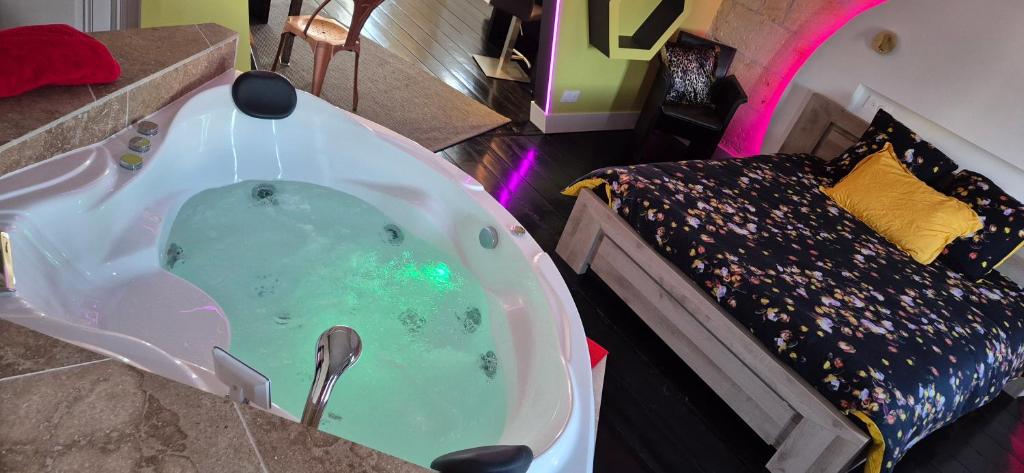 - un jacuzzi dans une chambre avec un lit dans l'établissement NOVA - - love room & suite, à Libourne
