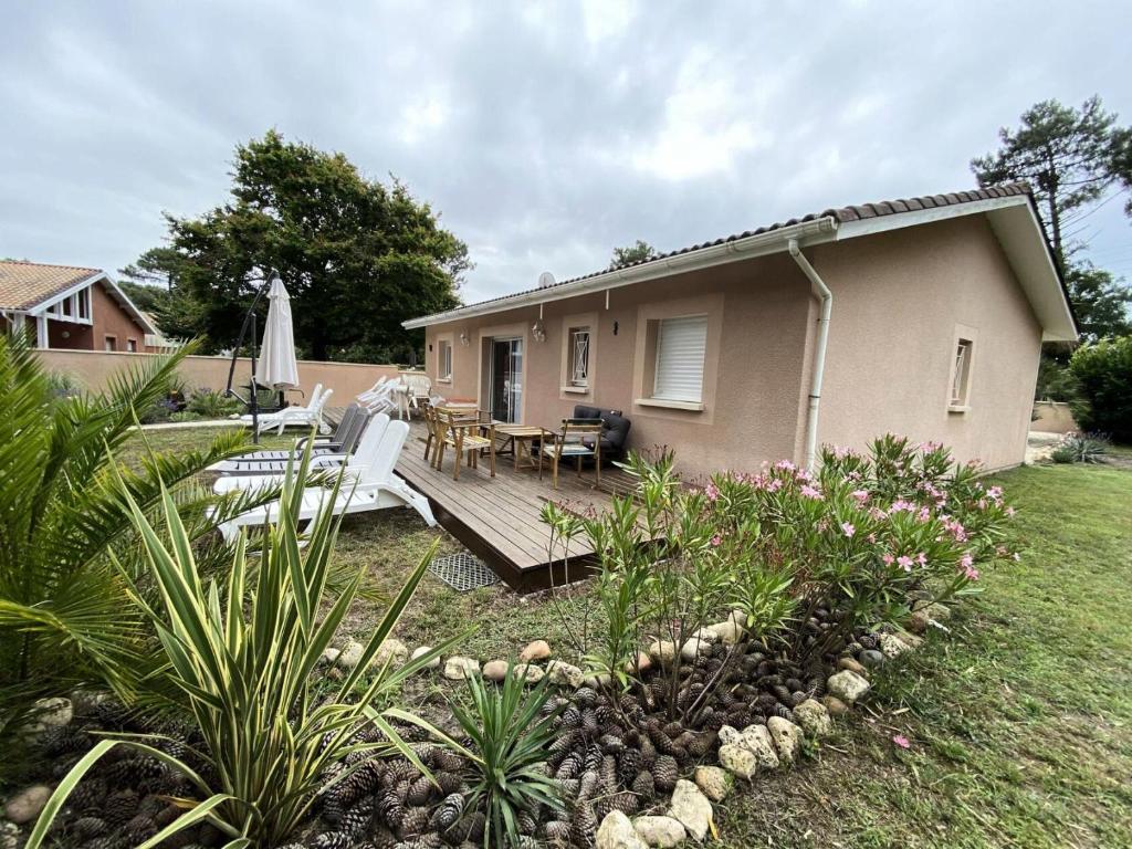 une petite maison avec une terrasse, une table et des chaises dans l'établissement Résidence La Grande Combe - 012 - Agréable villa dans quartier calme de Soulac/mer MAE-3721, à Soulac-sur-Mer