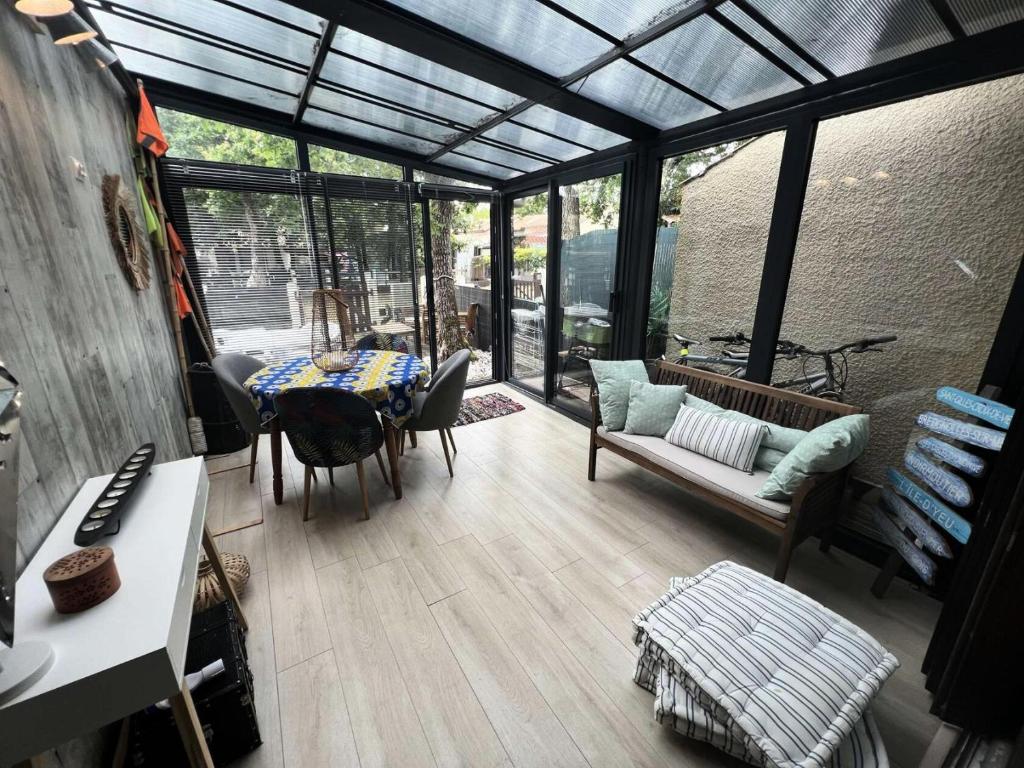 Cette chambre dispose d'une véranda avec une table et des chaises. dans l'établissement Résidence Villa Atlantique - 020 - Maisonnette au calme dans une petite résidence familiale MAE-9611, à Soulac-sur-Mer