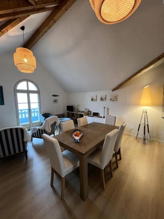 une salle à manger avec une table et des chaises en bois dans l'établissement Résidence Le Clos Des Baïnes - 047 - Magnifique appartement classée 3 avec vue sur l'océan MAE-9651, à Soulac-sur-Mer