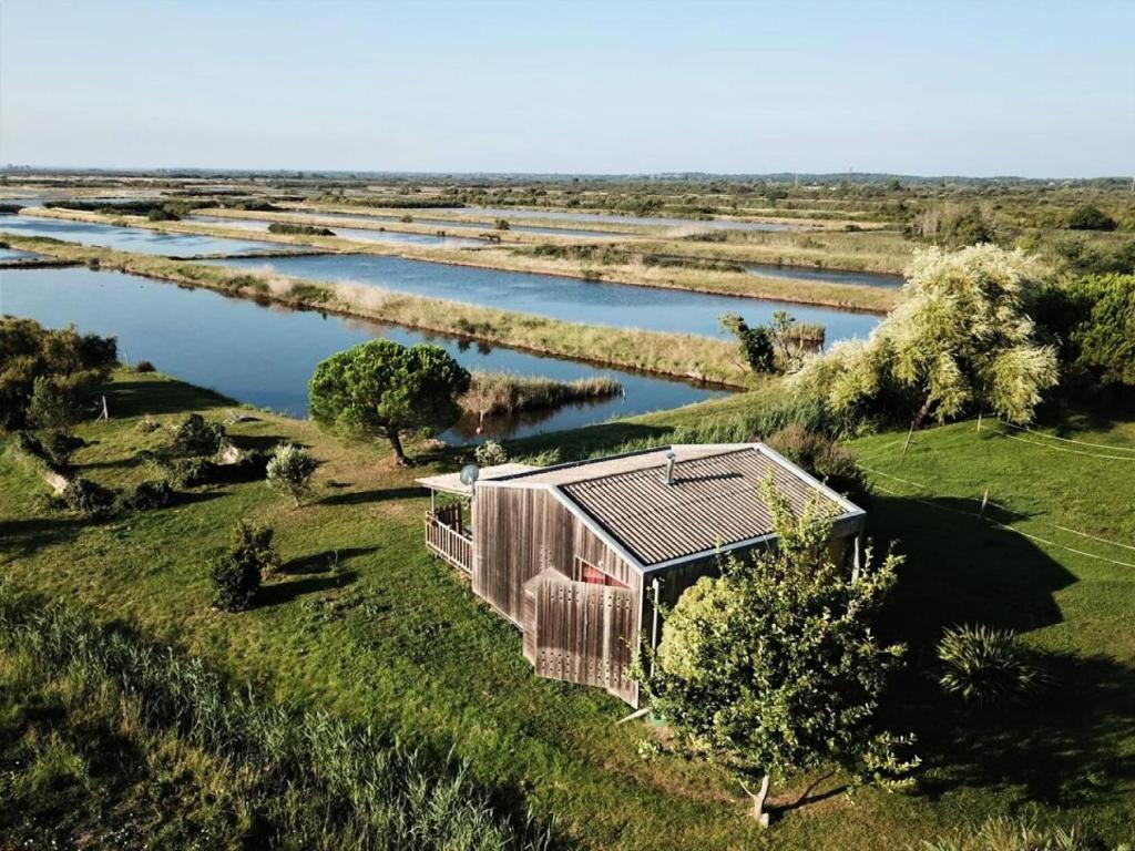 une vue aérienne d'un bâtiment à côté d'une rivière dans l'établissement Résidence 076-le Verdon Sur Mer - 076 - Dépaysagement total pour ce chalet en pleine nature MAE-9681, au Le Verdon-sur-Mer