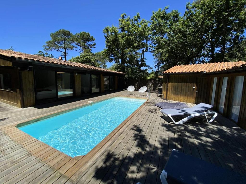 une piscine sur une terrasse à côté d'une maison dans l'établissement Résidence Terres Marine - 099 -Villa d'exception avec piscine à 2 mns des plages des Naïades MAE-9721, à Soulac-sur-Mer