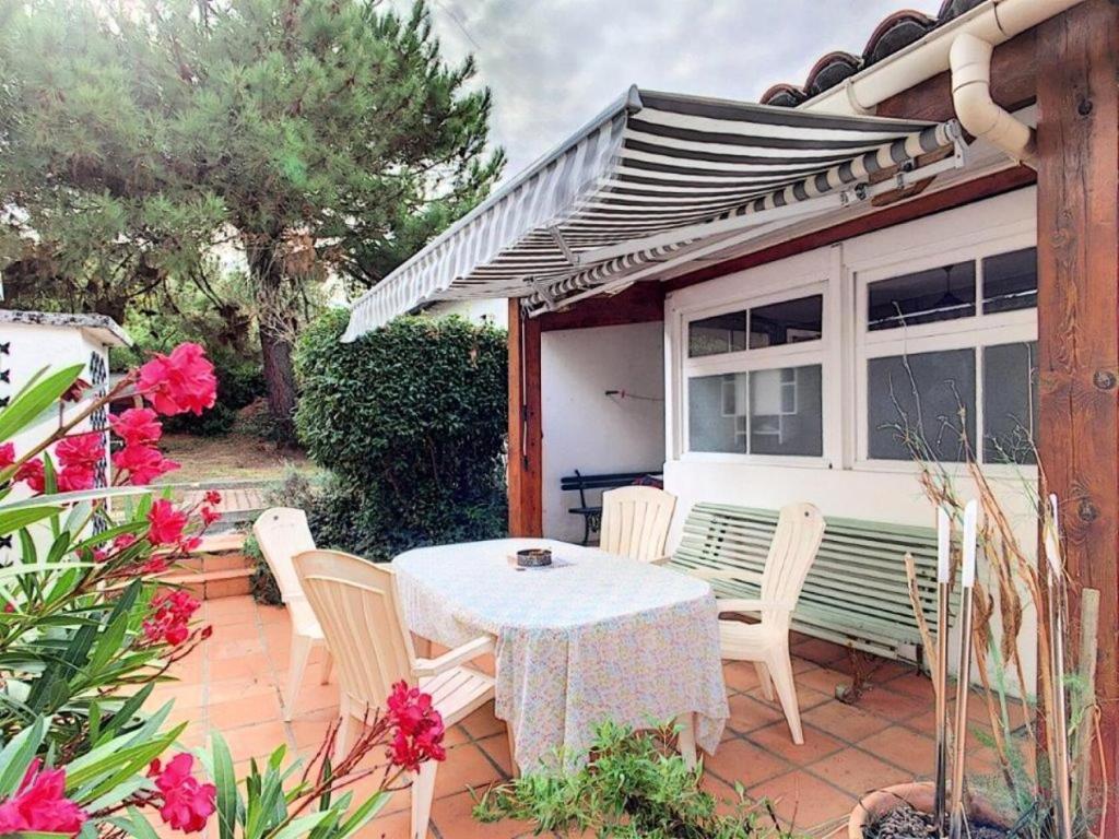 un patio avec une table et des chaises sur un patio dans l'établissement Résidence 055-soulac Sur Mer - 055 - Jolie maison proche du centre-ville MAE-1861, à Soulac-sur-Mer