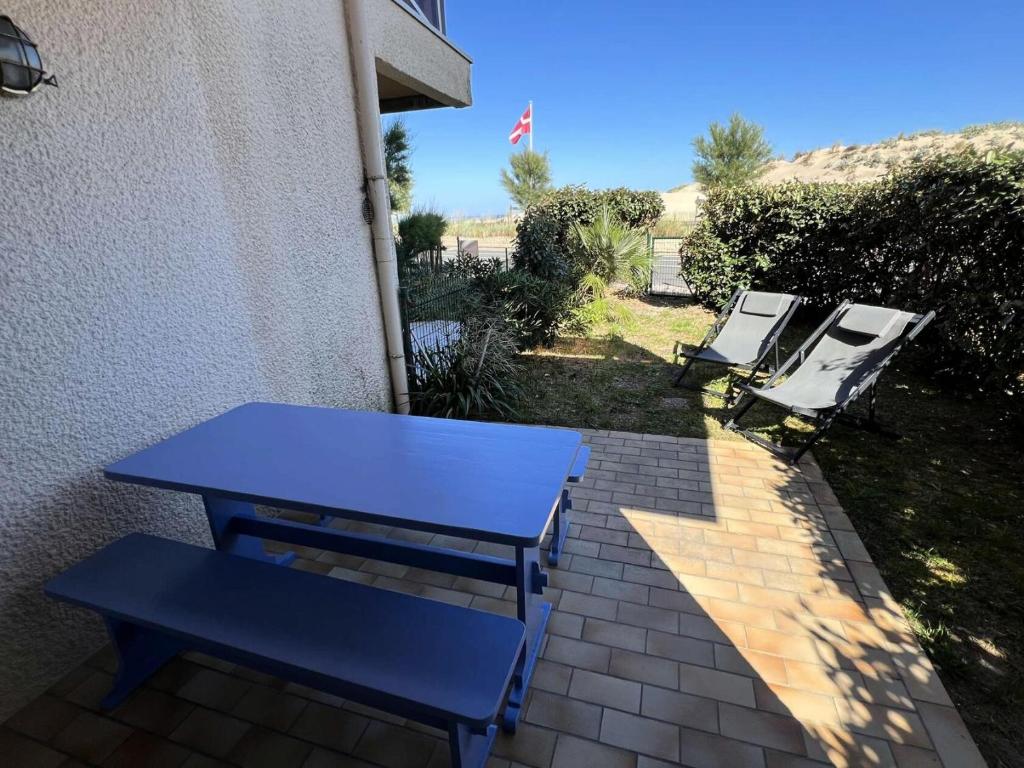 une table de pique-nique bleue et des chaises à côté d'un bâtiment dans l'établissement Résidence Cap Atlantic - 066 - Bel appartement en rez-de-jardin à quelques pas de la plage MAE-1971, à Soulac-sur-Mer