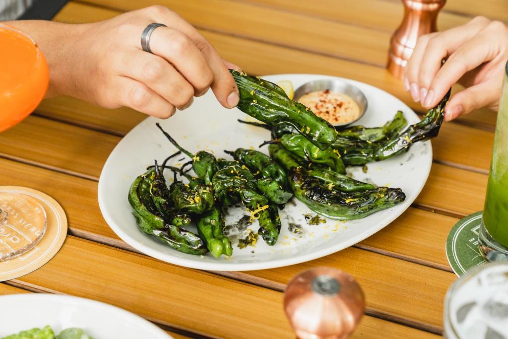 a plate of food with green peppers on a table at Aloft Austin Downtown in Austin