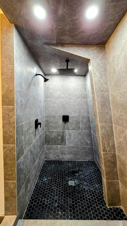 a bathroom with a shower with a black tile floor at Coalition Lodge in Park City