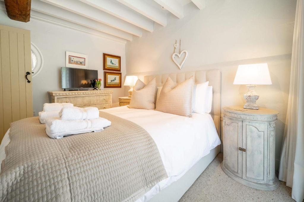 a bedroom with a white bed with towels on it at Newly Refurb Cottage, Mile From Blakeney, Village Pub and Restaurant in Langham
