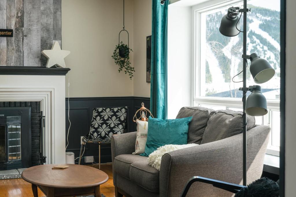 a living room with a couch and a fireplace at La Maison du Sentier - Foyer et Mt Porphyre in Murdochville