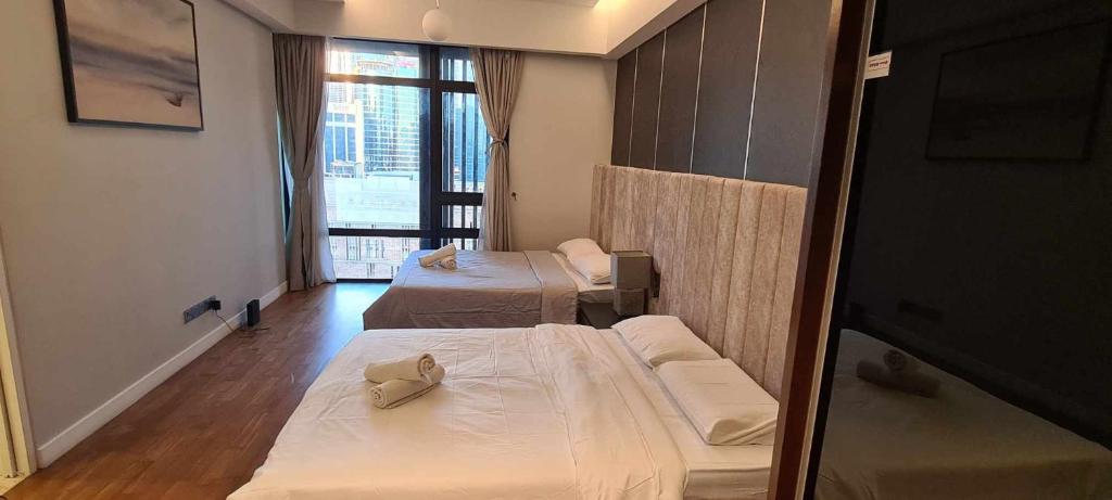 a hotel room with two beds and a window at Anggun Residences Luxe in Kuala Lumpur