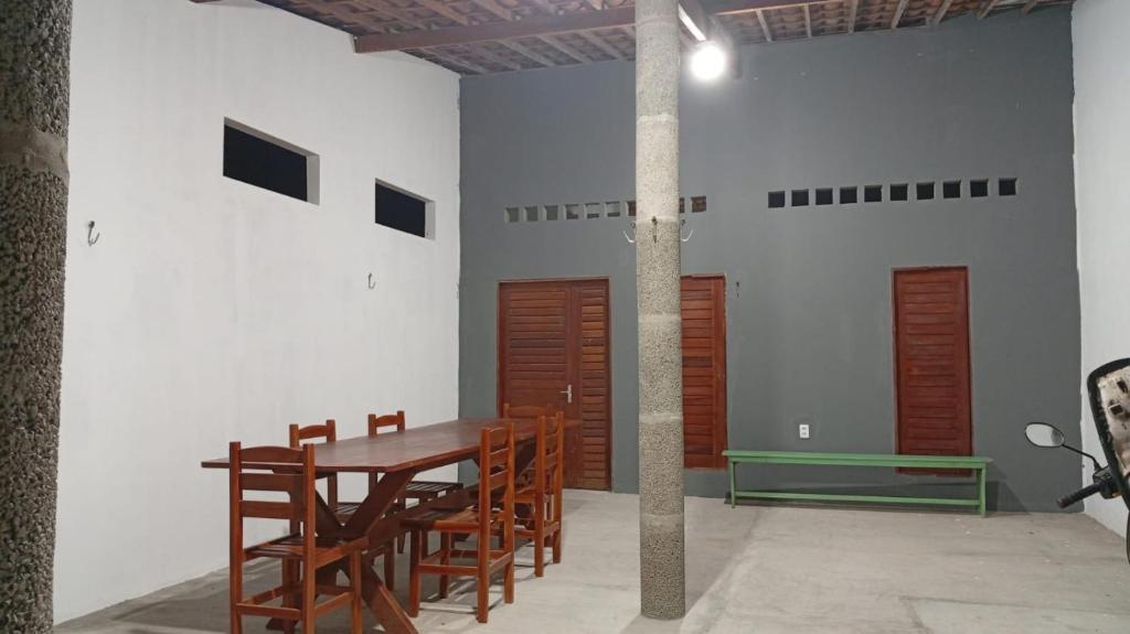 a dining room with a wooden table and chairs at Casa de Praia - Icapui - Ce - Praia de Requenguela in Icapuí