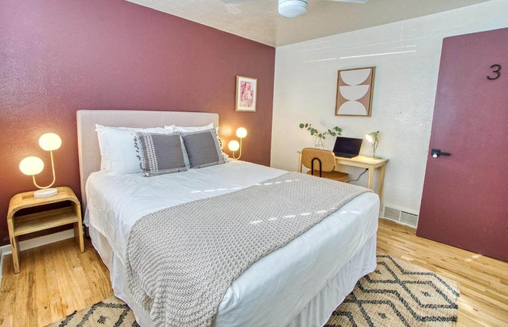 a bedroom with a large bed and a purple wall at Joy House in Golden