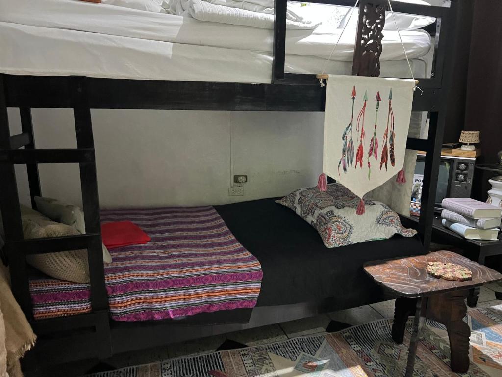 ein Schlafzimmer mit zwei Etagenbetten und einem Tisch in der Unterkunft Mendoza’s GUEST HOUSE in Santa Ana