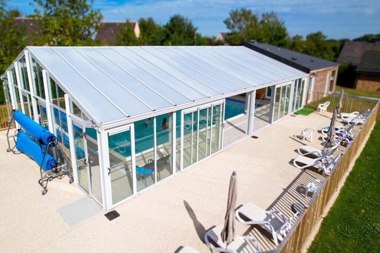 une maison en verre avec une piscine et des chaises dans l'établissement Chalet in Normandy near Veules-les-Roses, à Veules-les-Roses