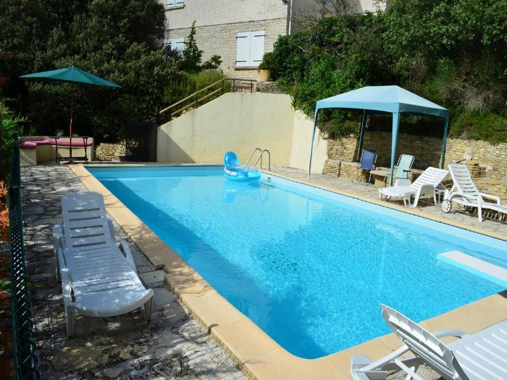 - une piscine avec des chaises et un jouet bleu dans l'établissement Holiday Home in France with Private Pool, à Le Pègue
