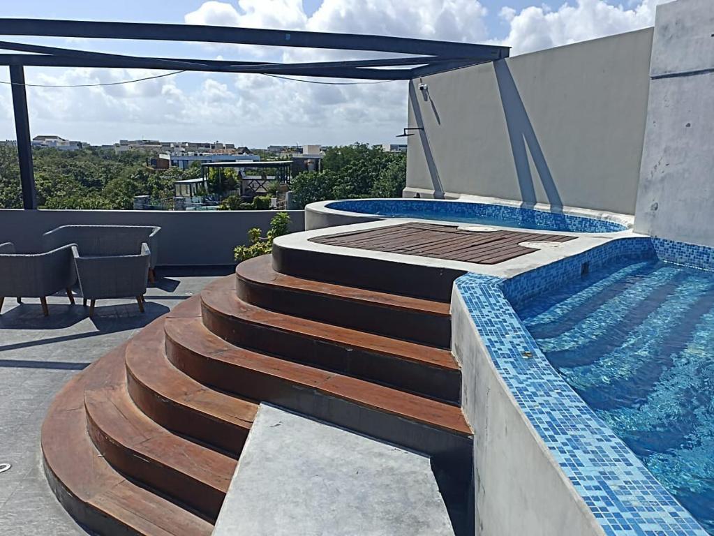 a swimming pool and stairs next to a swimming poolvisor at Phimai, Tu Lugar Magico En Tulum in Tulum