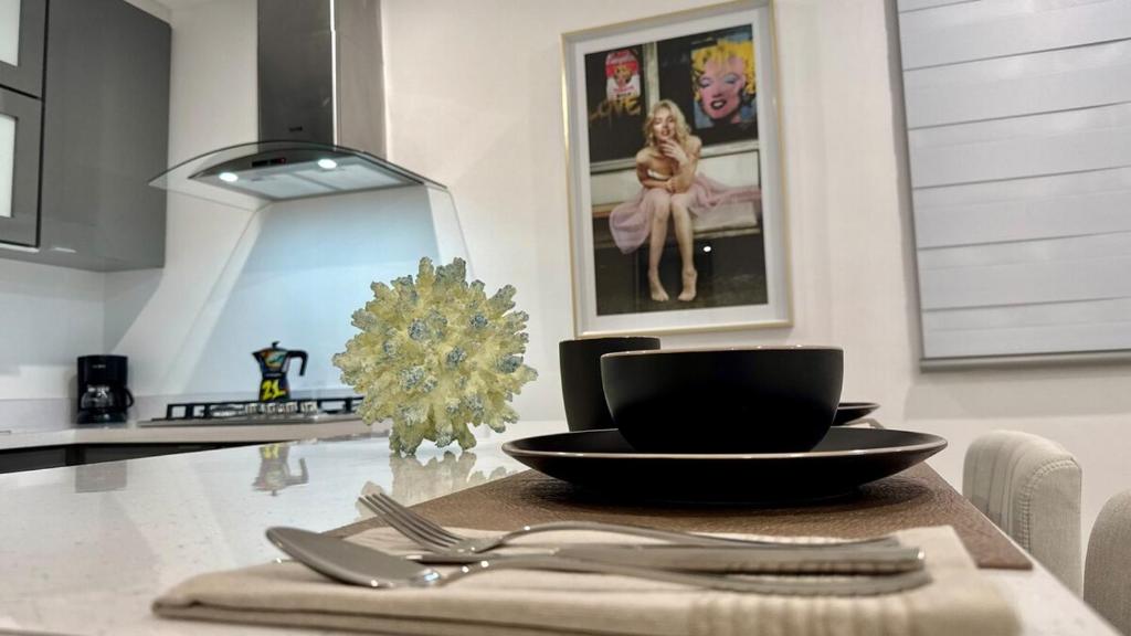 een keuken met een tafel, een zwarte kom en keukengerei bij 961 Studio in San Juan