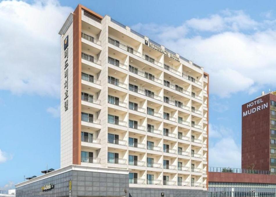 保宁市Mud Beach Hotel的一座大型酒店大楼,前面有标志