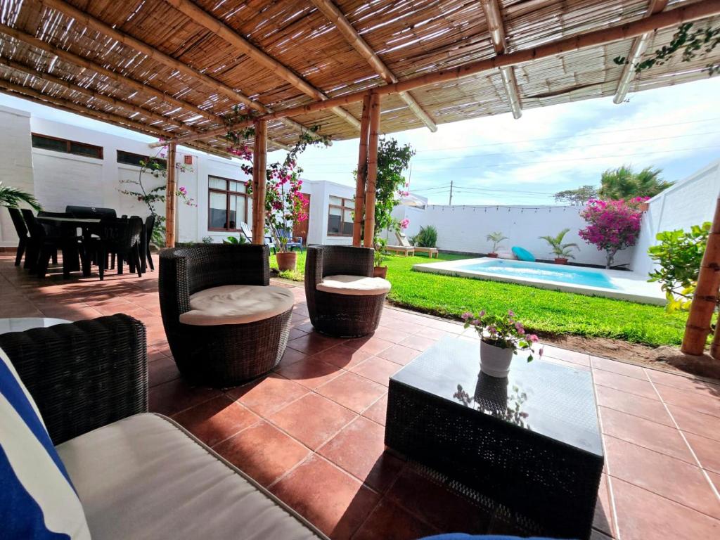 パラカスにあるCasa Charme en la Residencial de Paracasのパティオ(椅子、テーブル、プール付)