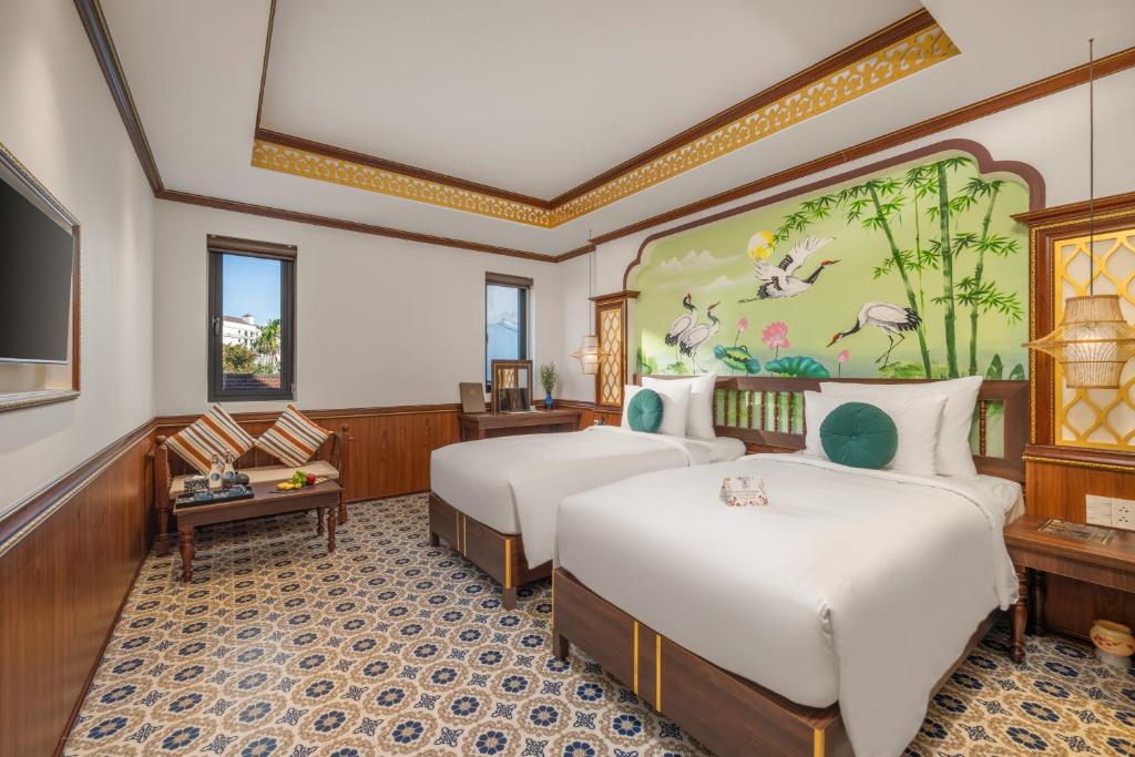 Postel nebo postele na pokoji v ubytování Hoi An Babylon Riverside Hotel & Spa