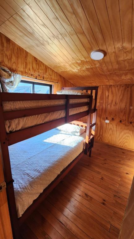 a bedroom with two bunk beds in a cabin at La Casa de Coke in Hualaihué