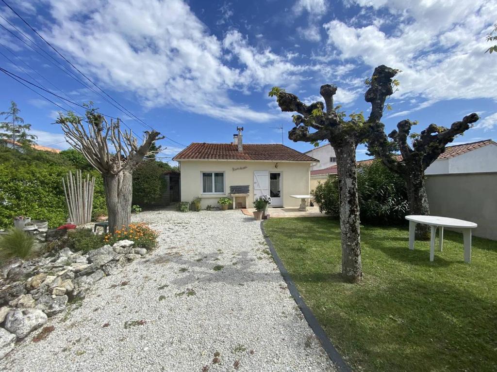 une maison avec une allée en gravier et une table dans la cour dans l'établissement Villa T4 à Vaux-sur-Mer, proche plages, jardin et terrasses - FR-1-738-42, à Vaux-sur-Mer