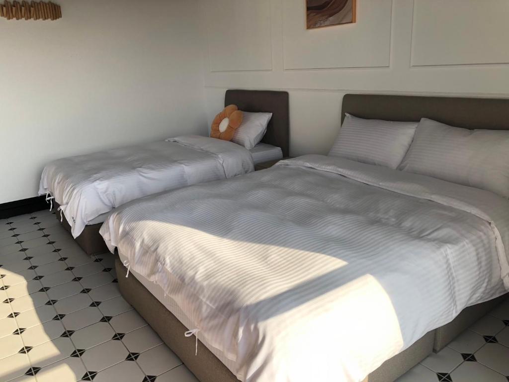 due letti uno accanto all'altro in una camera da letto di Stroll at Wudao Inn a Jinhu