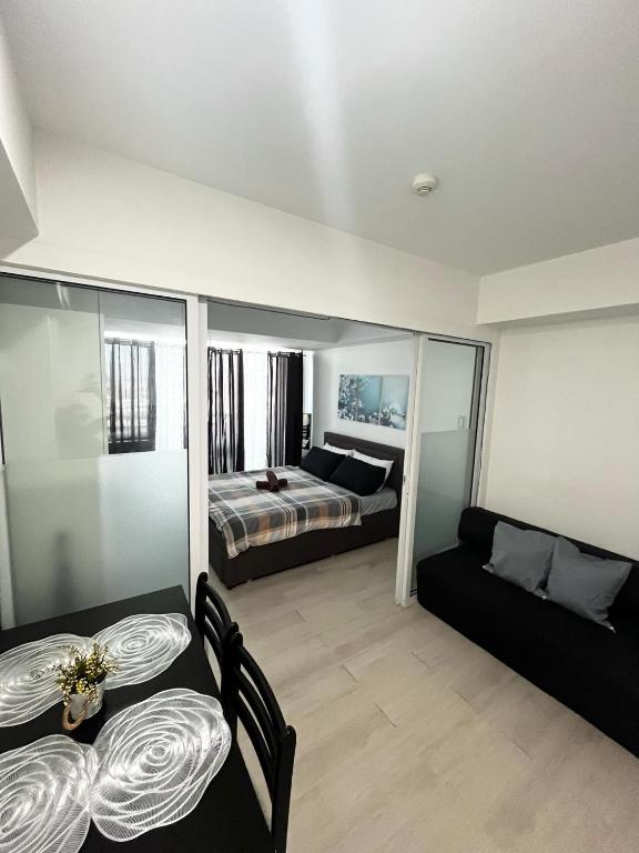 a living room with a bed and a couch at Azure Staycation by Casa Lepap in Manila