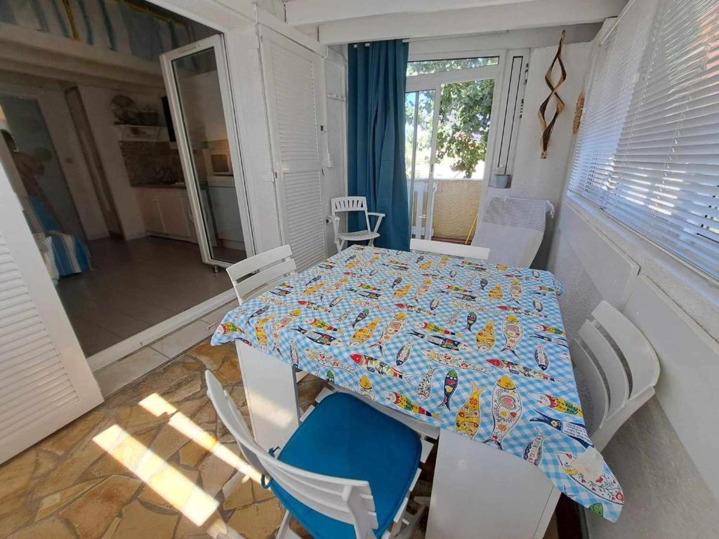 - une table et des chaises dans une salle avec une table et une salle à manger dans l'établissement Appartement avec loggia et parking privé, proche de la plage - FR-1-326-842, à Marseillan