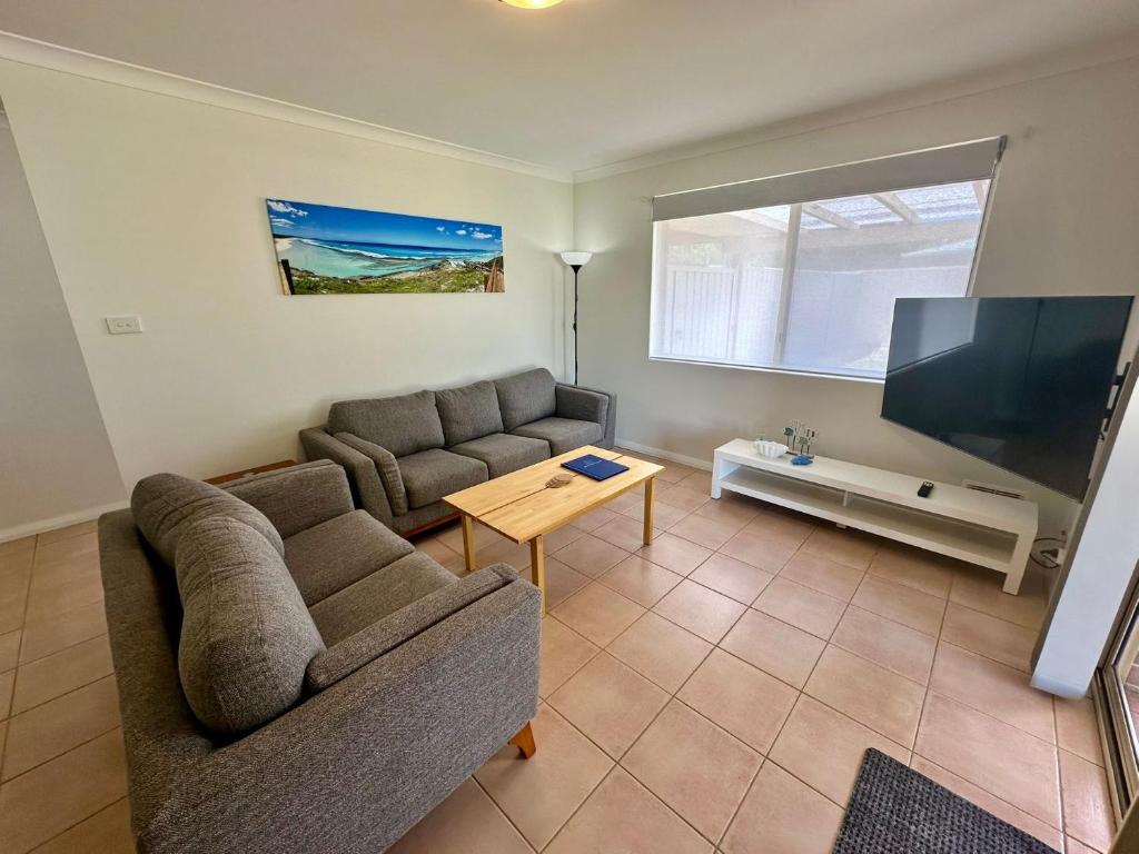 un soggiorno con divano e TV a schermo piatto di Geographe Bay Holiday Stay a Geographe