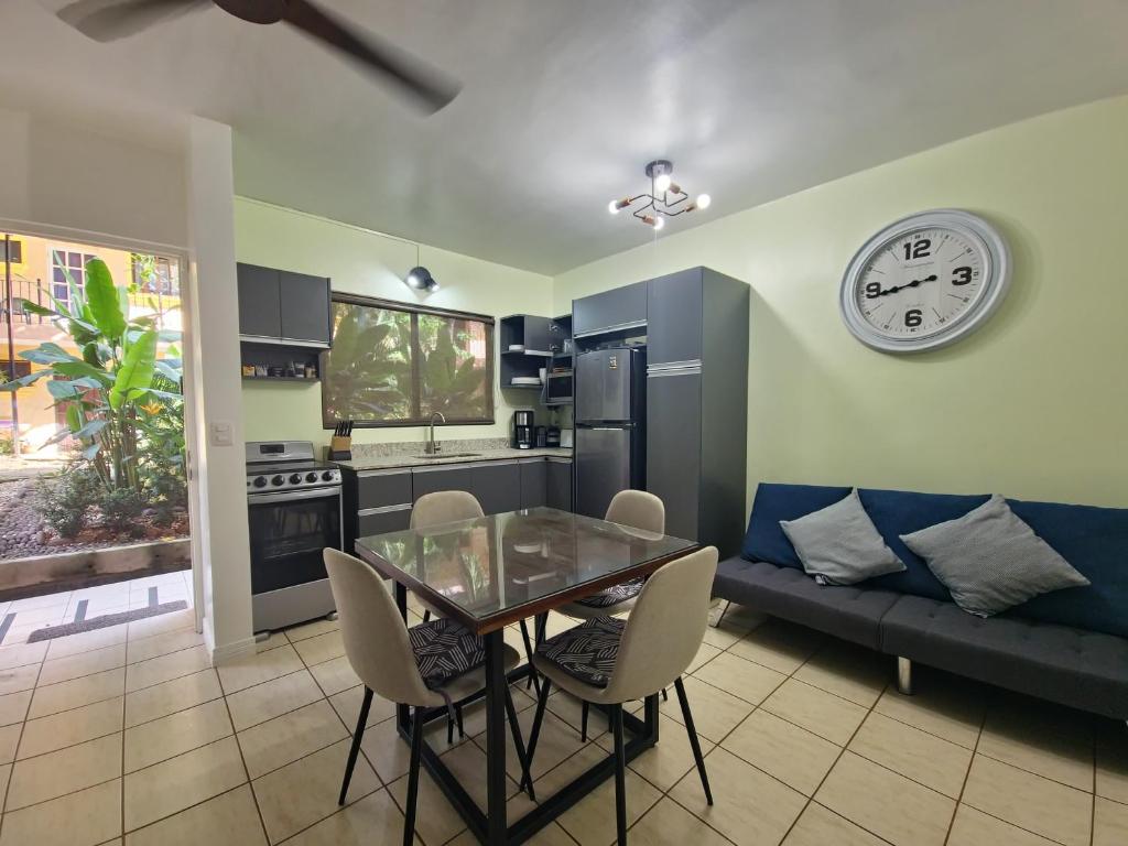 a kitchen with a dining table and a clock on the wall at A Little Bit Of Paradise Ground Floor Studio in Coco