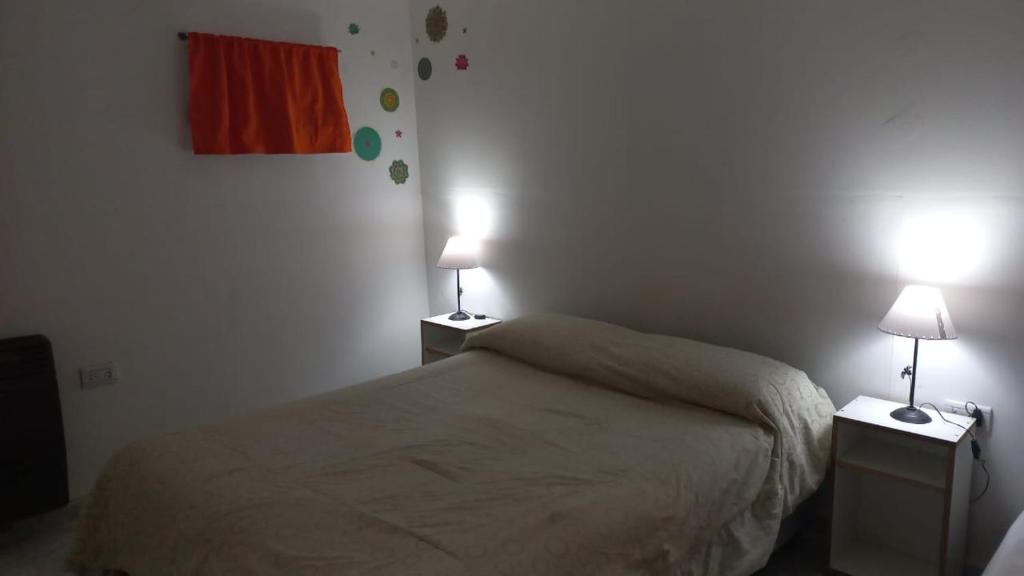 ein Schlafzimmer mit einem Bett und zwei Lampen an Tischen in der Unterkunft Jeleta 1 in Puerto Madryn