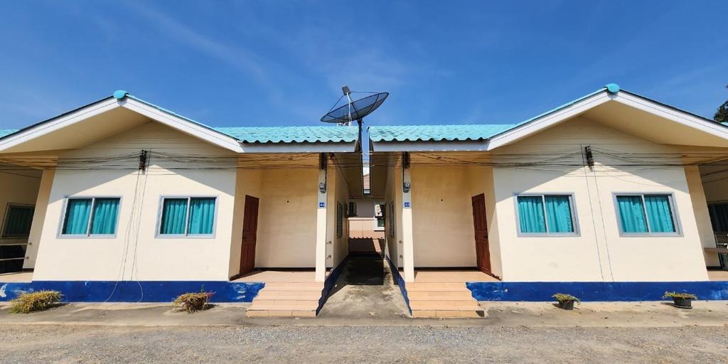 佛统Chok Phikul Thong Resort的一栋带蓝色窗户和卫星的建筑