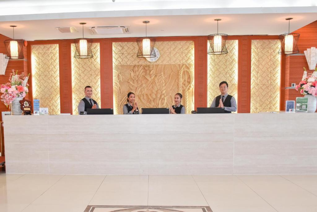 um grupo de pessoas sentadas em um balcão com laptops em Timor Plaza Hotel & Apartments em Dili