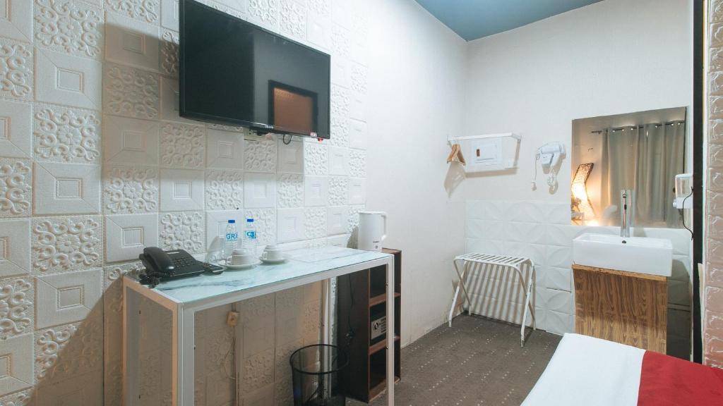 TV a/nebo společenská místnost v ubytování RedDoorz Premium at THE GRAND PENINSULA SUITES