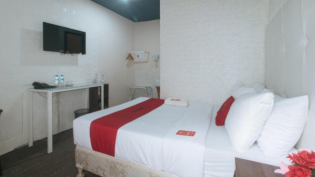 Postel nebo postele na pokoji v ubytování RedDoorz Premium at THE GRAND PENINSULA SUITES