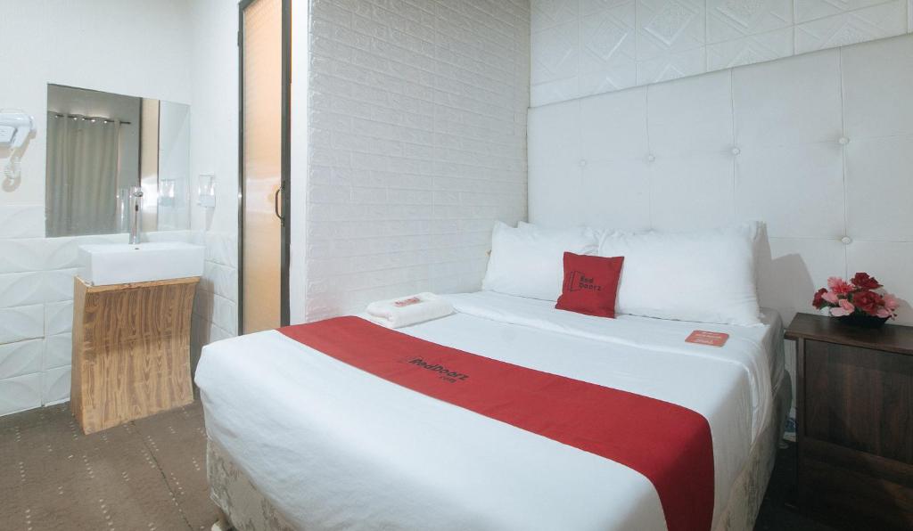 Postel nebo postele na pokoji v ubytování RedDoorz Premium at THE GRAND PENINSULA SUITES