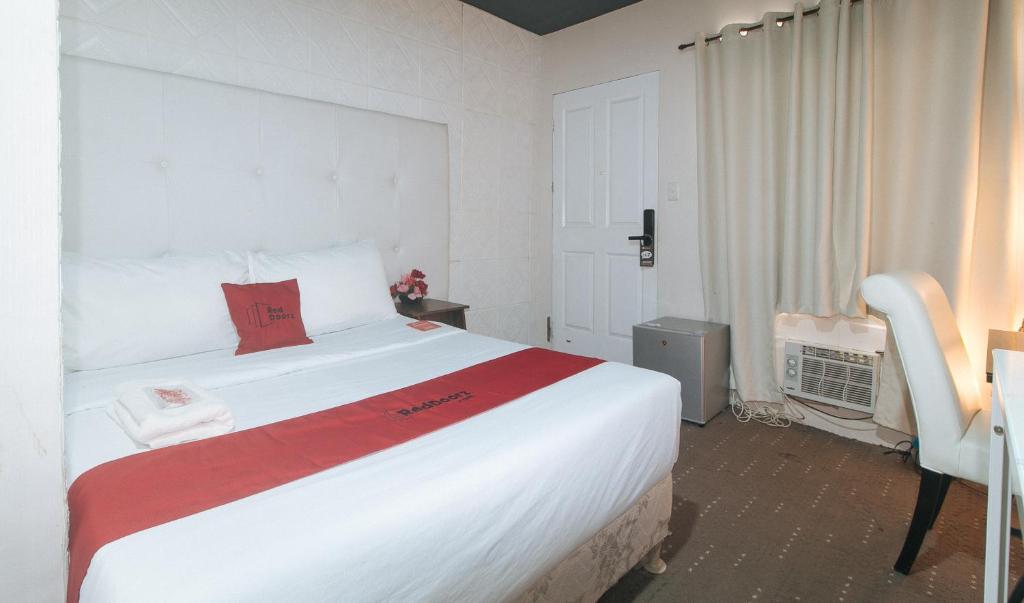 Postel nebo postele na pokoji v ubytování RedDoorz Premium at THE GRAND PENINSULA SUITES