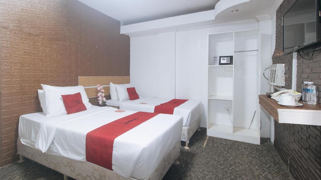 Postel nebo postele na pokoji v ubytování RedDoorz Premium at THE GRAND PENINSULA SUITES